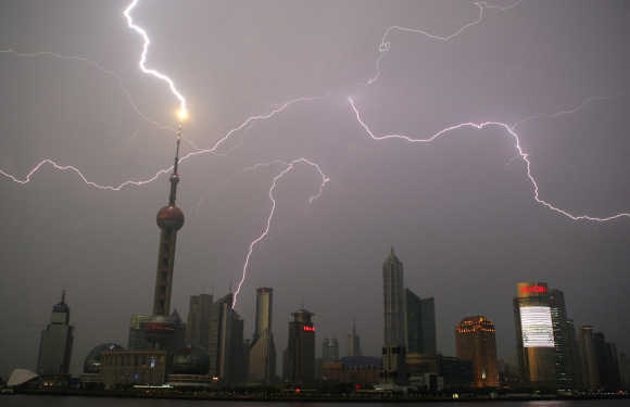 Bolt of lightning strikes Oriental Pearl Tower as others light up skyline above Pudong financial district in Shanghai.