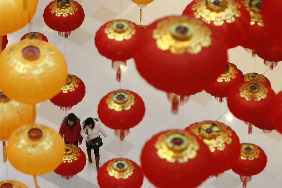 People walk under lanterns at a shopping mall in Shanghai.