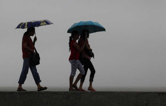 Girls walk on a seaside promenade as it rains in Mumbai. A file photo.