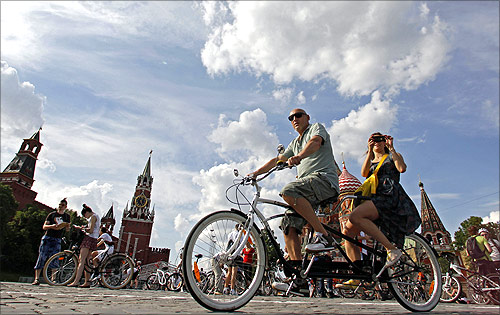 People cycle by the Kremlin as they take part in the Let's bike it! bike ride in central Moscow.