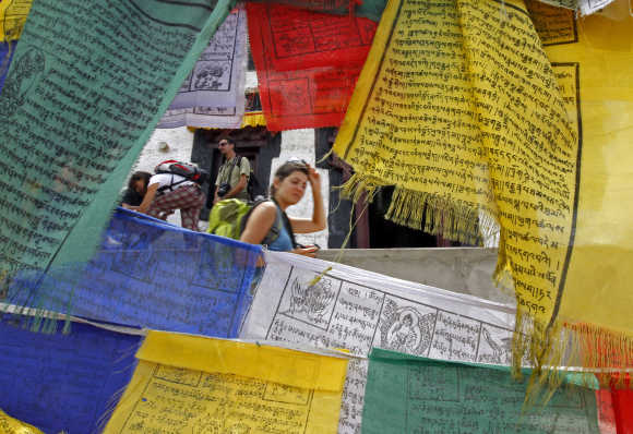 A French tourist walks past Buddhist religious flags at Namgyal Tsemo Gompa monastery in Leh.