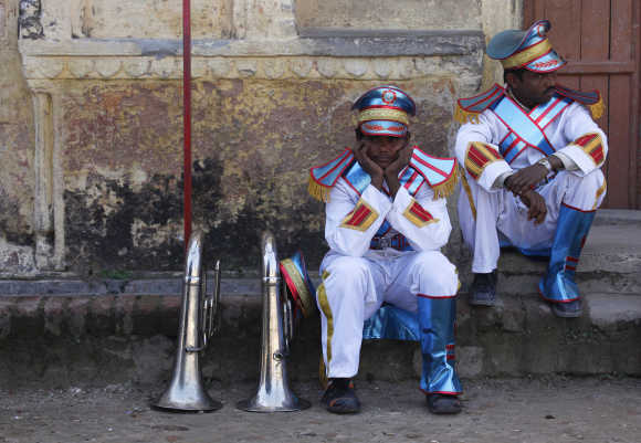 Musicians rest as they wait to take part in a parade during the Kumbh Mela in Haridwar.