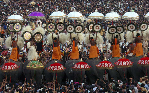 People attend a procession of decorated elephants at Trichur district.