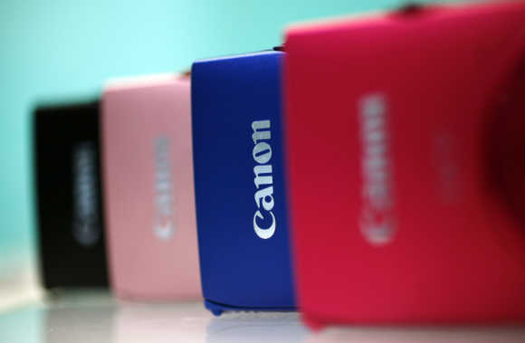 Digital cameras from Canon Inc.'s compact IXY series are displayed at a showroom in Tokyo.