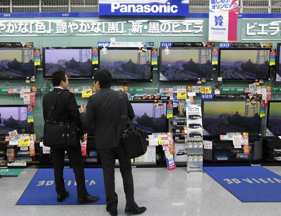 Men look at Panasonic's TV sets at an electronic shop in Tokyo.