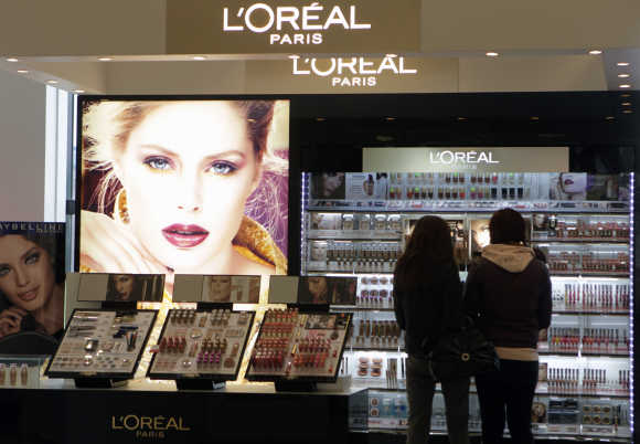 Customers look at LOreal cosmetics in the shop in Riga, Latvia.