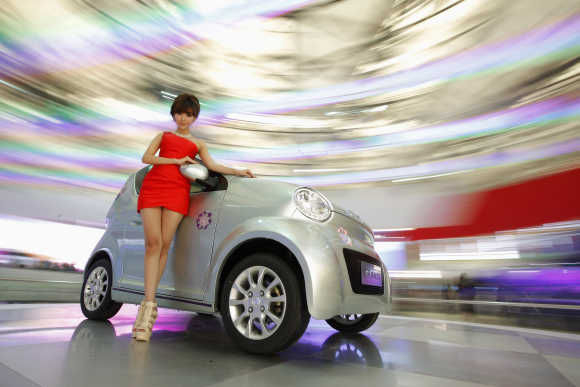 A model poses next to the Dongfeng EJ02 during the opening day of the Shanghai Auto Show.