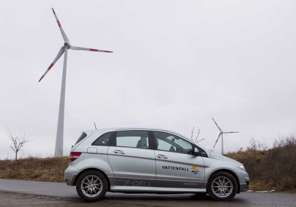 A Mercedes hydrogen-powered car drives near wind turbines that contribute energy to a hybrid power plant near the town of Schenkenberg north of Berlin.