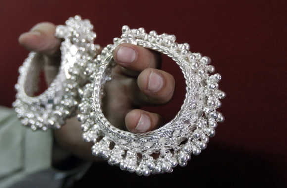 A trader displays silver ornaments inside his shop in Ahmedabad.