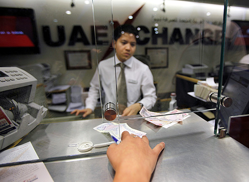 A customer exchanges money at a currency exchange center in Dubai.