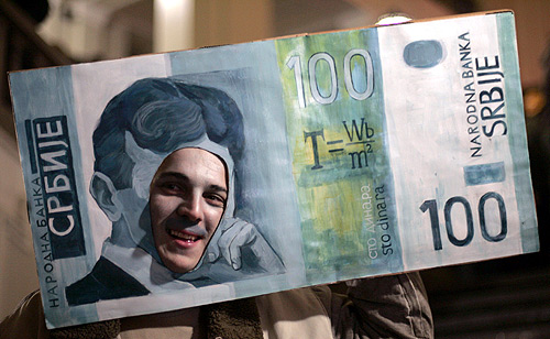 A student from the technical science faculty at the University of Belgrade wears an oversized 100-dinar banknote with a portrait of Nikola Tesla during a masked ball in Belgrade.