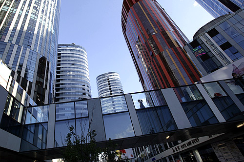 A woman walks between buildings at Sanlitun SOHO residential and commercial complex in Beijing.