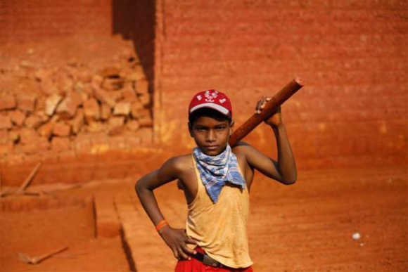 Mithun, 11, poses for a photo at a laterite brick mine in Ratnagiri district, about 360km south of Mumbai. He is paid Rs 2 per brick and carries an average of 100 bricks out of the mine per day. Each brick costs between Rs 10-14, and weighs around 40kg.