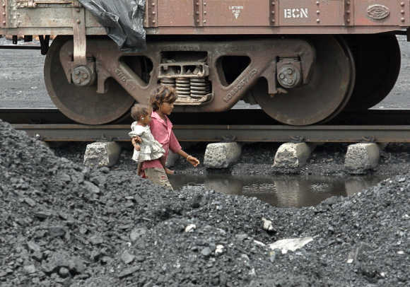 Children of labourers walk beside a railway track on the outskirts of Ahmedabad.