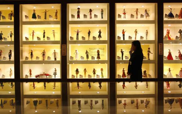 A curator walks past displays of Barbie dolls at the Doll Industry Museum in Taishan, Taipei County.