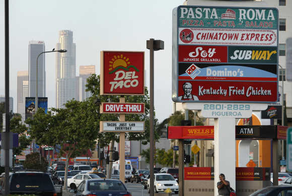 Signs of fast food restaurants are seen along a busy street in Los Angeles.