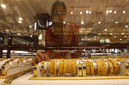 A saleswoman arranges gold jewellery inside a showroom in Kolkata.