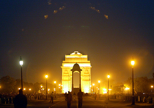People walk near the historic India Gate on a hot evening in New Delhi.