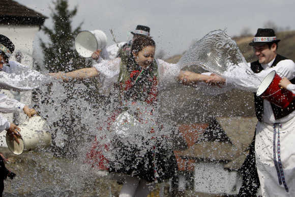 Men hold onto a girl as they throw water at her as part of traditional Easter celebrations in Holloko, 100km east of Budapest.