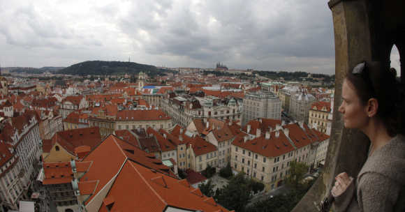 A tourist looks at Czech capital Prague from Old Town Hall Tower at historical Old Town Square.