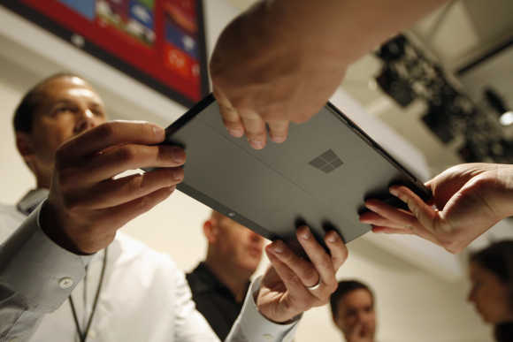 Microsoft representative hands the Surface tablet to a member of the press in Los Angeles, California.