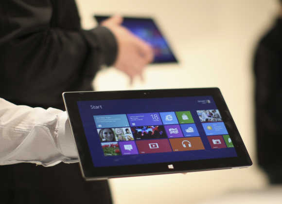 Microsoft representatives hold the Surface tablet computer as it is unveiled in Los Angeles.