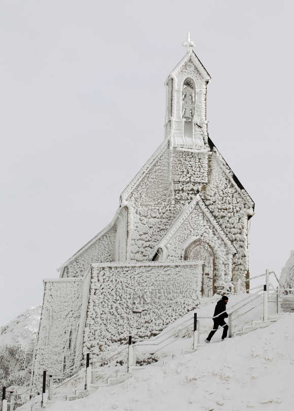 A man walks below a frost covered Wendelstein church, Germany's highest church, on the 1,838 metres (6,030 feet) high Wendelstein mountain near Bayrischzell.