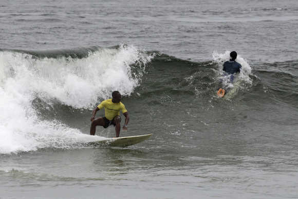 Competitors ride waves at the third annual Surf Liberia Contest at Robertsport on the coast of the West African nation.