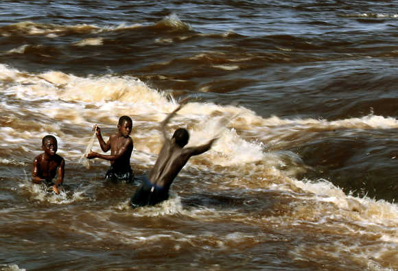 Boys throw fishing net in Congo River on outskirts of the capital Kinshasa.