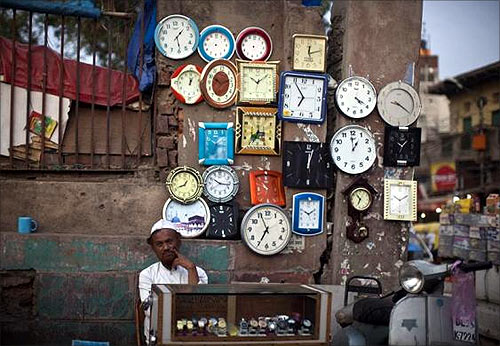 A roadside vendor waits for customers at his stall of clocks and watches in the old quarters of Delhi.
