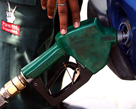 A worker fills a car with fuel at a petrol station in New Delhi.