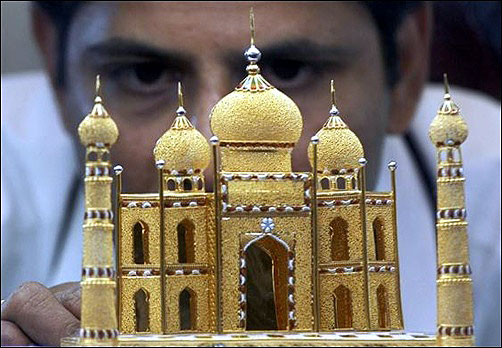 A worker displays a miniature 22 carat gold replica of the historic Taj Mahal at the India international jewellery exhibition in Chennai.