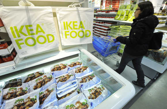 A shopper walks past food refrigerator and Ikea branded bags at Wembley branch in west London.