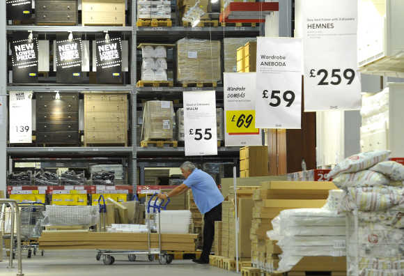 A shopper pushes goods past Ikea signs at the Wembley branch in west London.