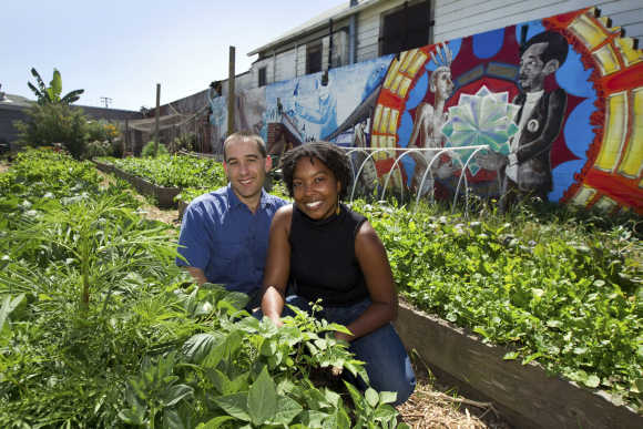 Braham Amadi and Nikki Henderson pose in a community garden behind a low-income housing development in Oakland, California.