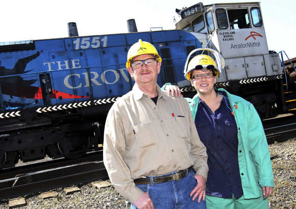 ArcelorMittal Mill employees Ed Goans stands with his daughter Kathleen Wilmink, as a ArcelorMittal train passes by, in Cleveland, Ohio.