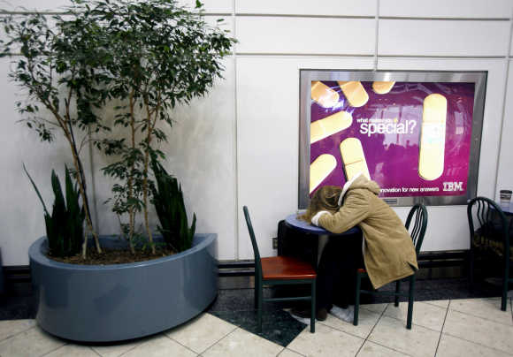 A woman sleeps on a table, a day before Thanksgiving, at the Newark International Airport in Newark, New Jersey.