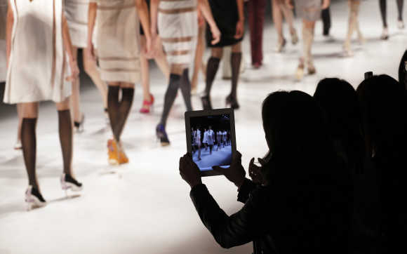 A spectator uses an iPad to record Gloria Coelho's Summer 2012/2013 collection during Sao Paulo Fashion Week.