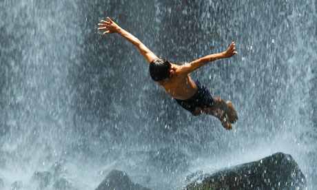 A boy jumps into the Llanos del Cortes waterfall in Bagaces, Costa Rica