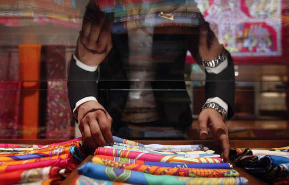 A saleswoman arranges scarves inside a Hermes showroom in Mumbai.
