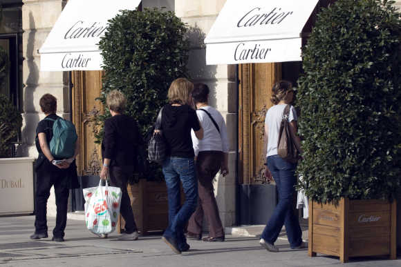People look at a window display of luxury goods maker Cartier in Paris' Place Vendome.
