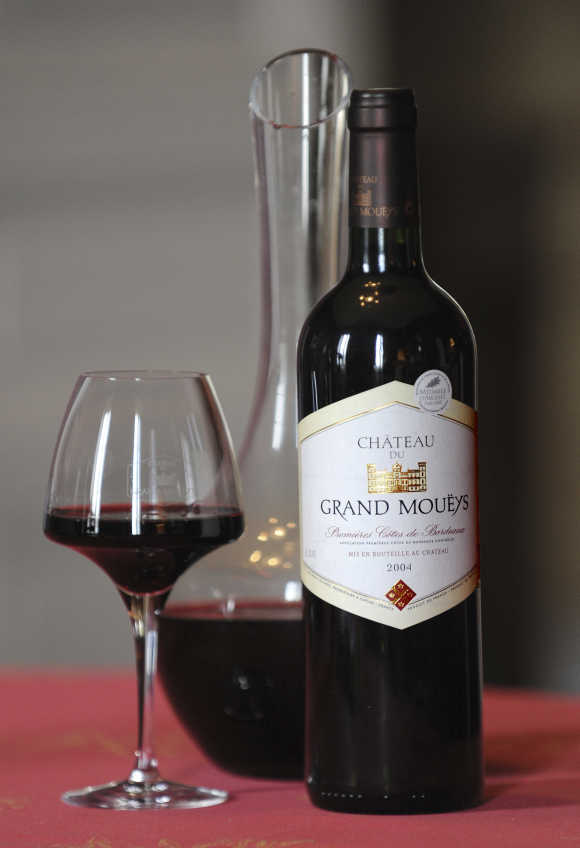 A carafe, a glass and a bottle of Chateau du Grand Moueys red wine are displayed in the tasting room of the Chateau in Capian, France.