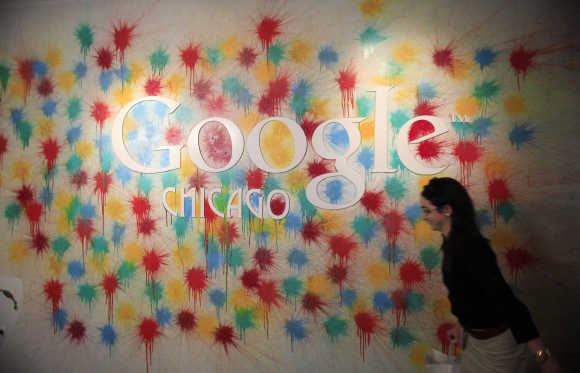 A woman walks past the Google Chicago headquarters logo in Chicago.