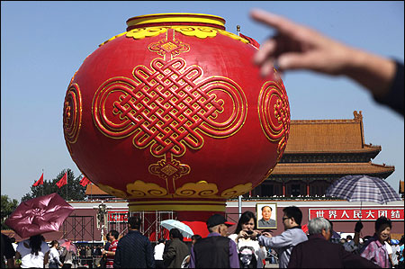 Tourists walk around a giant red lantern on display at Tiananmen Square for the National Day celebrations.