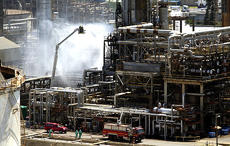 Fire fighters extinguish a fire at the Engen oil refinery in Durban.