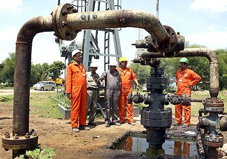 Engineers of Oil and Natural Gas Corp (ONGC) stand inside the Kalol oil field in Gujarat.