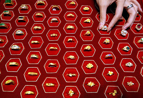 A shopkeeper poses with gold rings inside a jewellery shop in Taipei.