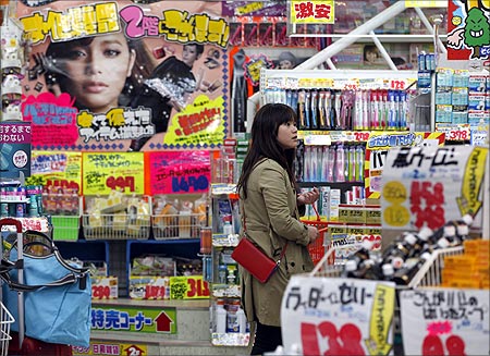A woman looks through products at a drug store in Tokyo.