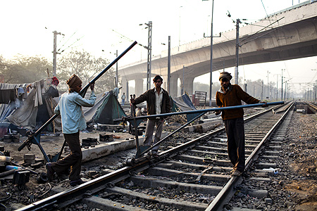 Indian labourers work on the tracks at Nizamuddin Railway Station.