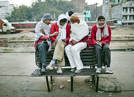 Workers take a break from unloading cargo from incoming trains at Nizamuddin Railway Station.
